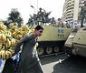 بائع متجوّل يمر بين دبابات الجيش في قلب القاهرة