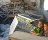 طفلان سوريان يبتسمان وسط دمار لحق بمدرستهما في حلب