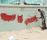 صورة أرشيفية لعامل يمسح عبارات مسيئة