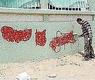 صورة أرشيفية لعامل يمسح عبارات مسيئة